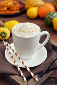 Pumpkin spice latte with whipped cream cinnamon and decorative pumpkins